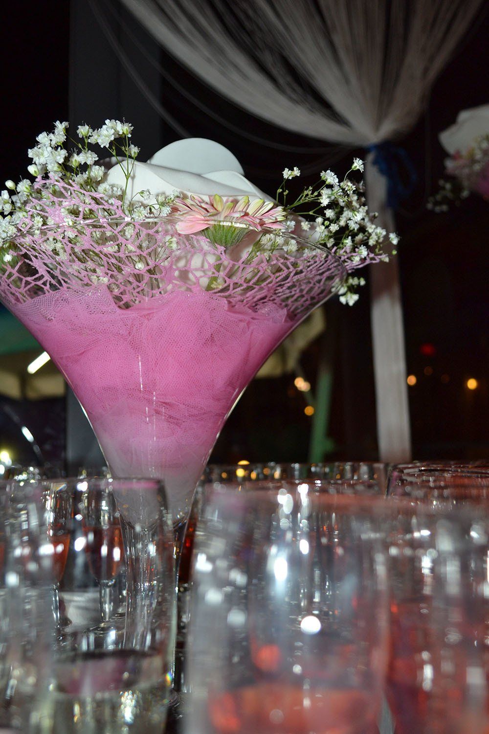Un bicchiere da martini pieno di liquido rosa e fiori