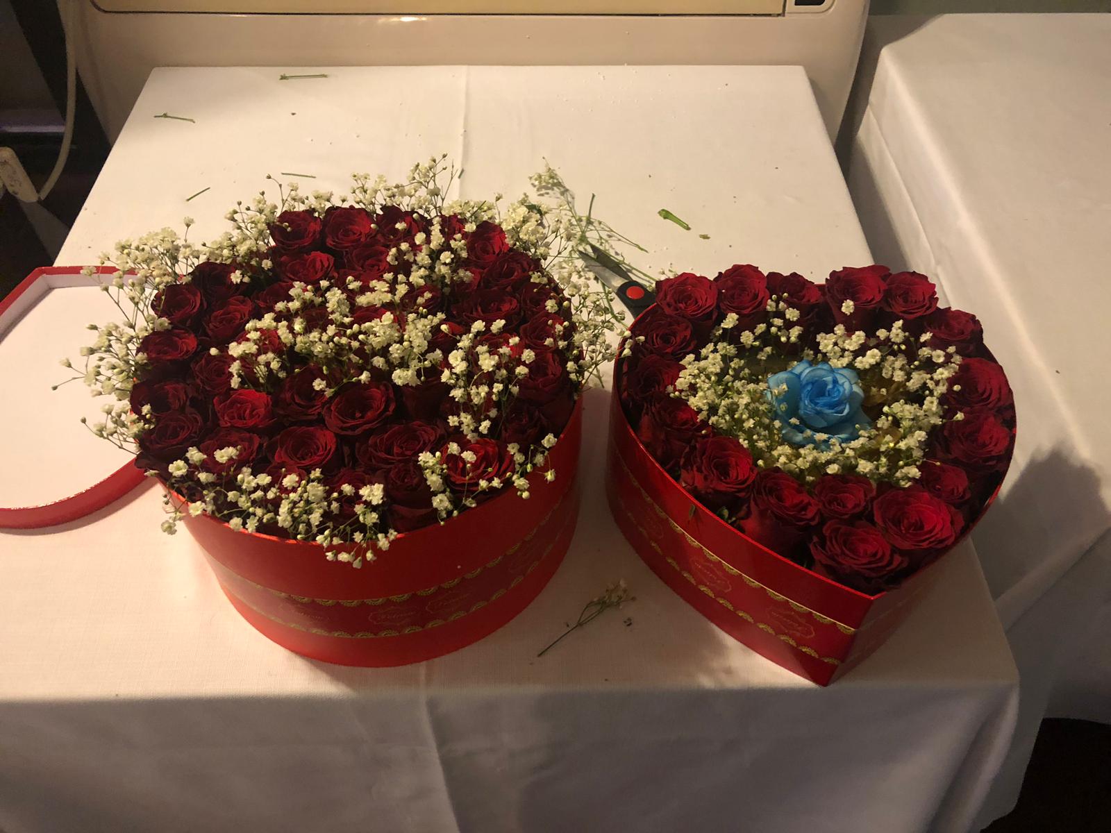 Due scatole a forma di cuore piene di rose rosse e gypsophila