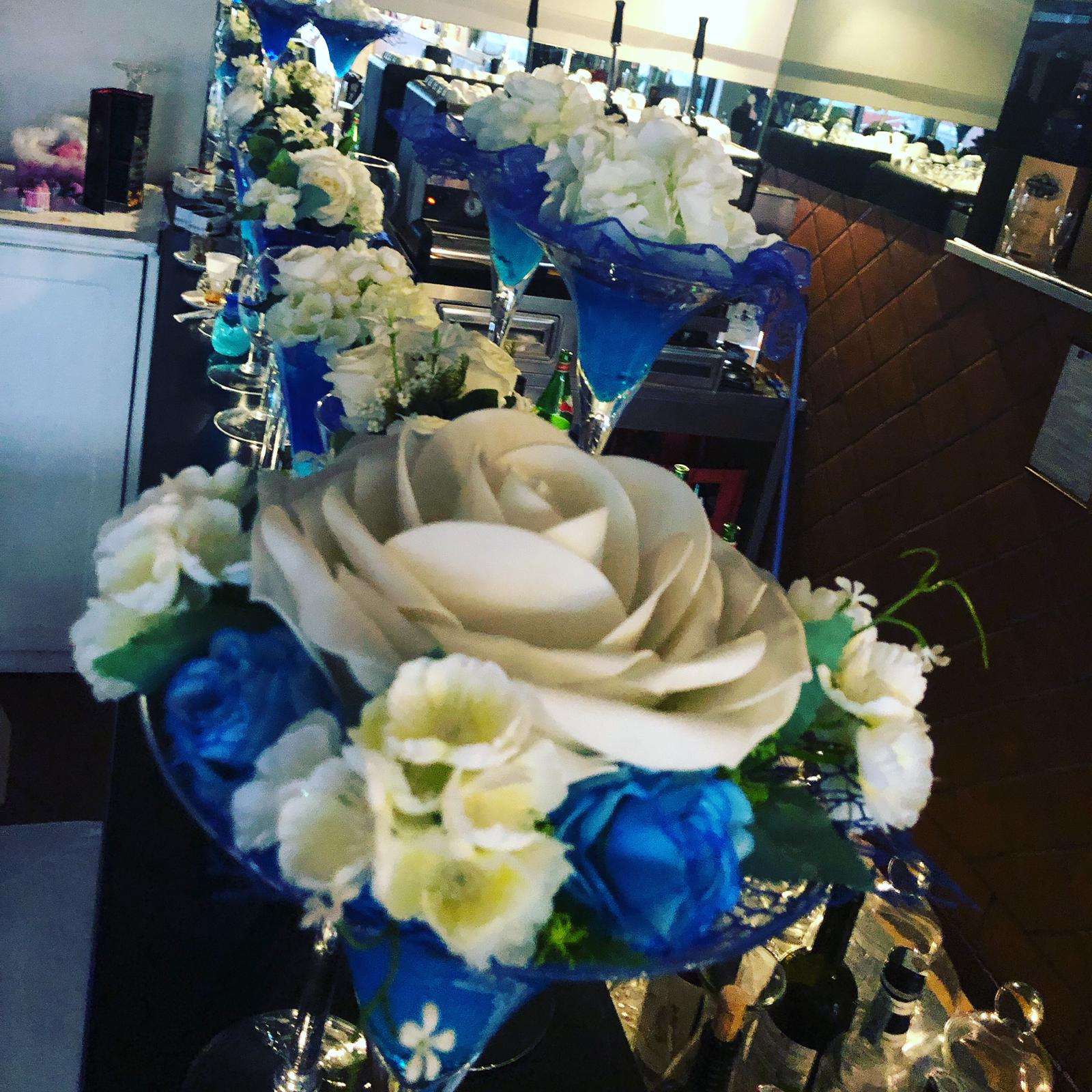 Una fila di bicchieri da martini decorati con fiori blu e bianchi