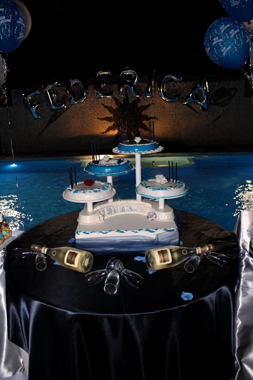 Un tavolo con una torta e bottiglie di champagne sopra