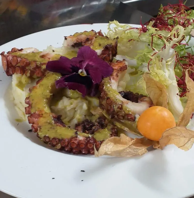 Un piatto di cibo con un fiore viola sopra