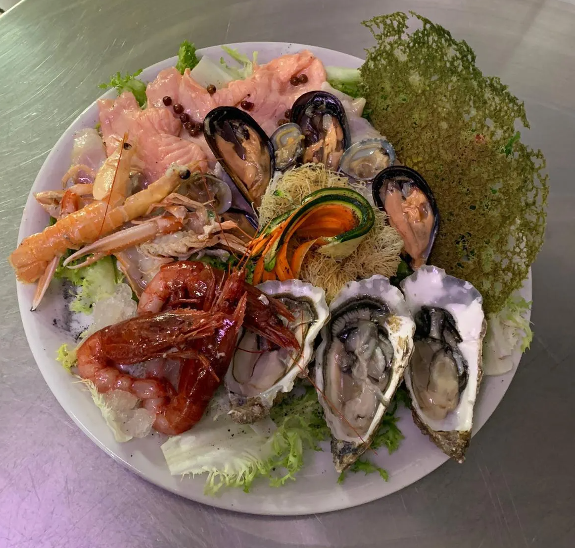 Un piatto di frutti di mare e verdure su un tavolo.