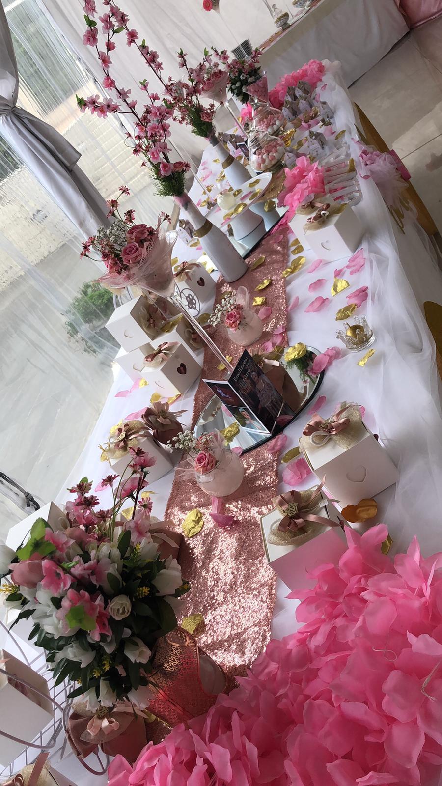 Un tavolo decorato con fiori rosa e torte per un baby shower.