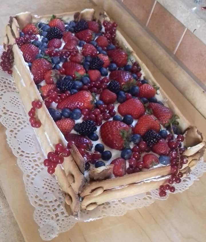 Una torta con fragole e mirtilli sopra