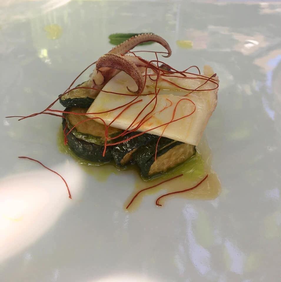 Un piatto bianco sormontato da una fetta di formaggio e verdure