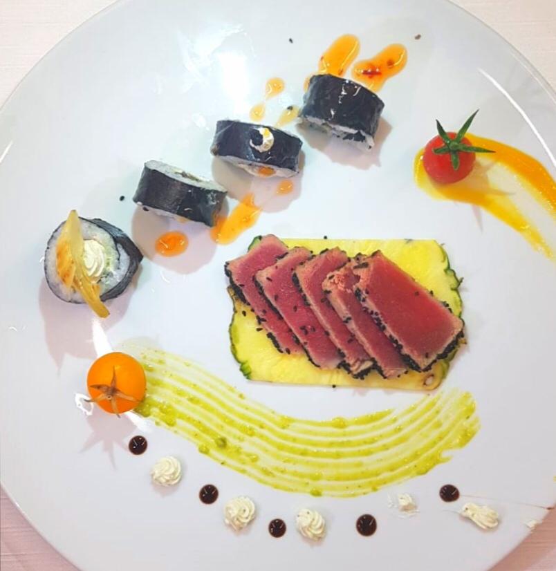 Un piatto bianco con sopra fette di carne e verdure