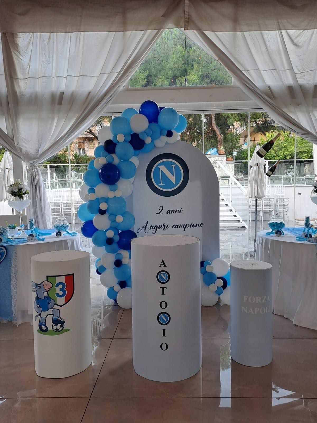 Una stanza decorata con palloncini blu e bianchi per una festa di compleanno.