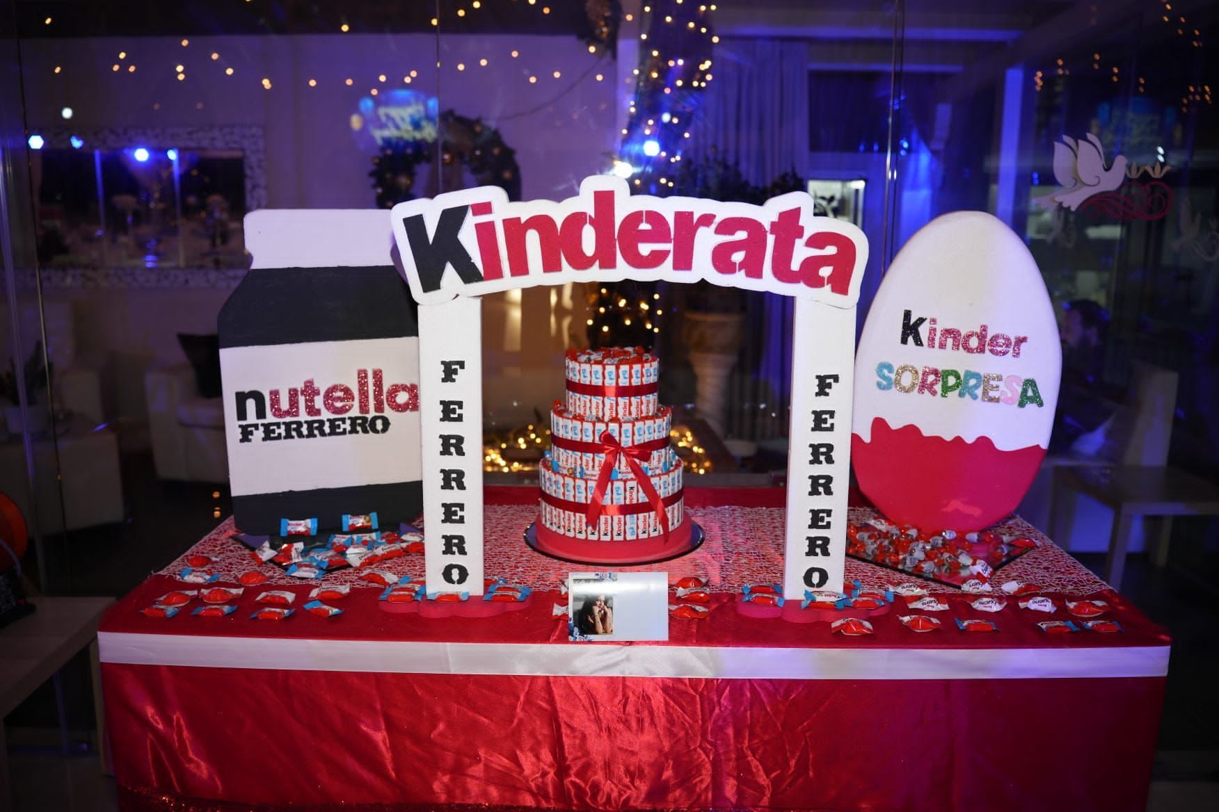 Un tavolo con una torta e un cartello con scritto kinderata