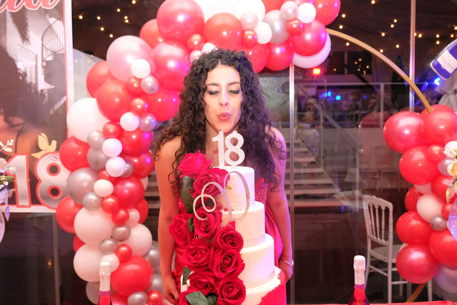 Una donna sta soffiando sulla candelina di una torta di compleanno.