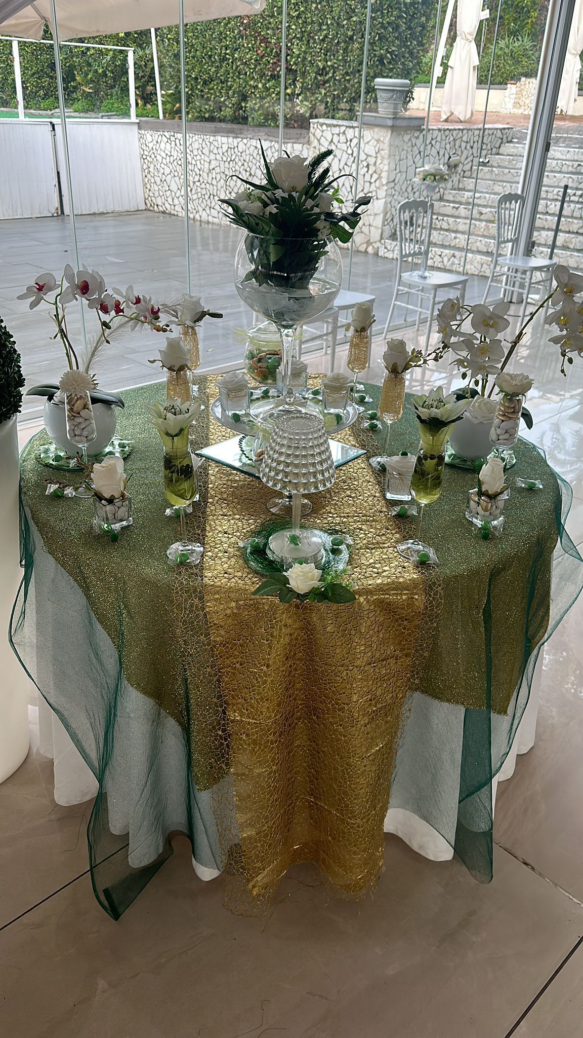Un tavolo con una tovaglia dorata e dei fiori sopra.