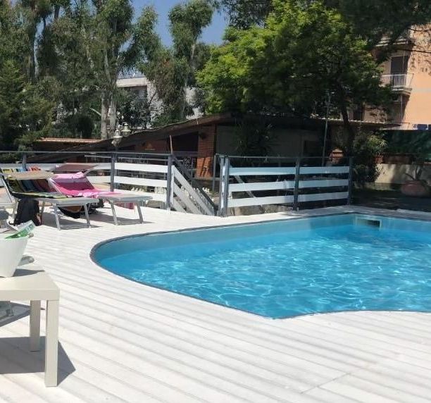 Una grande piscina circondata da sedie e una recinzione