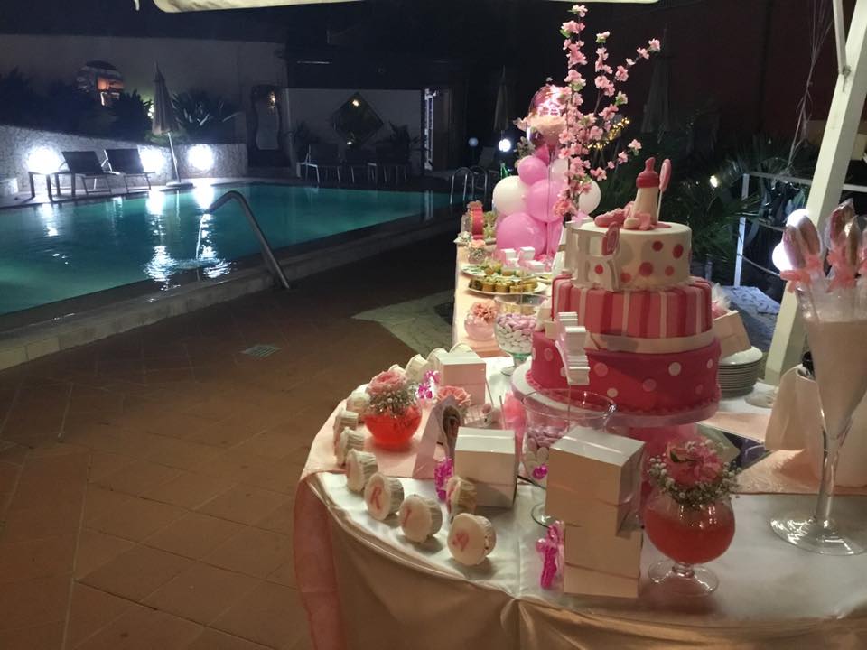 Un tavolo con una torta sopra e una piscina sullo sfondo