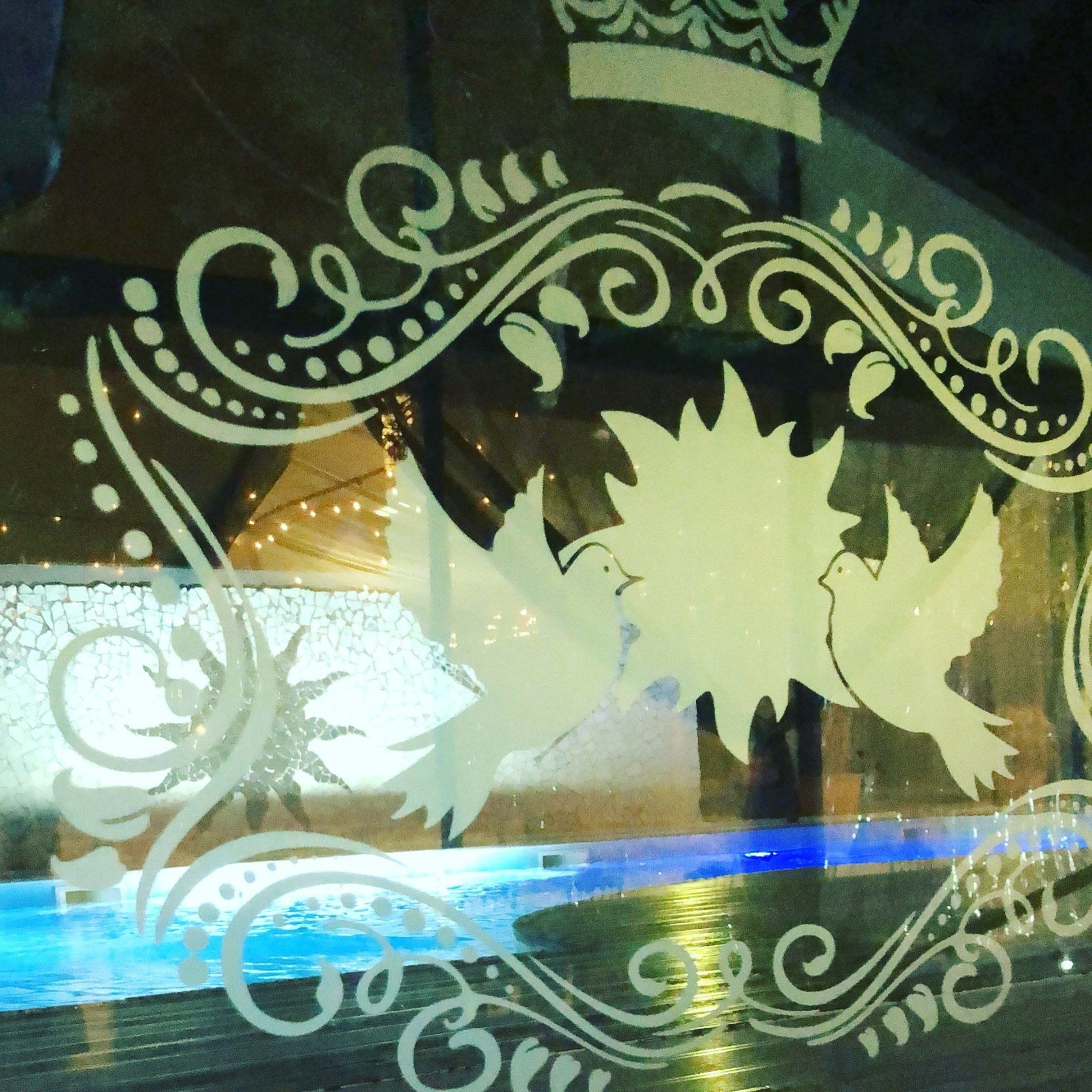 Una finestra con una corona e degli uccelli sopra