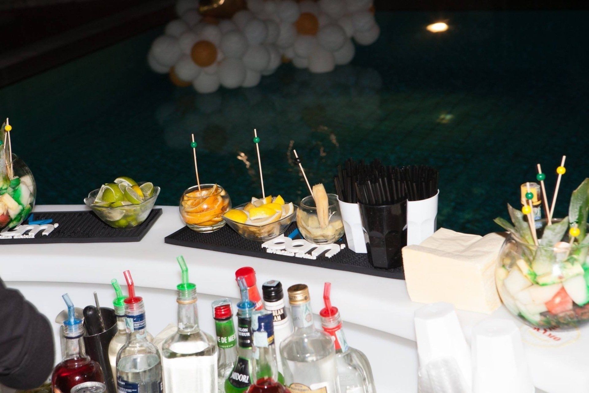 Un bar con bottiglie di liquore e frutta sopra