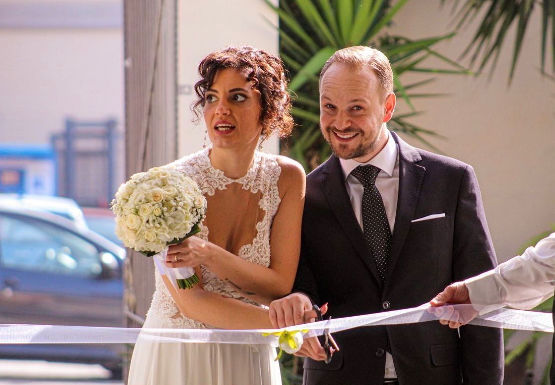 Una sposa e uno sposo tagliano il nastro al loro matrimonio.