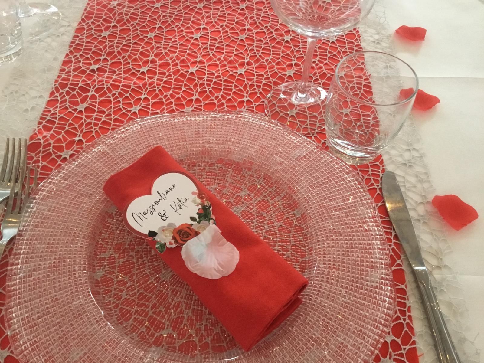 Un tovagliolo rosso con un cuore sopra è su un piatto su un tavolo.