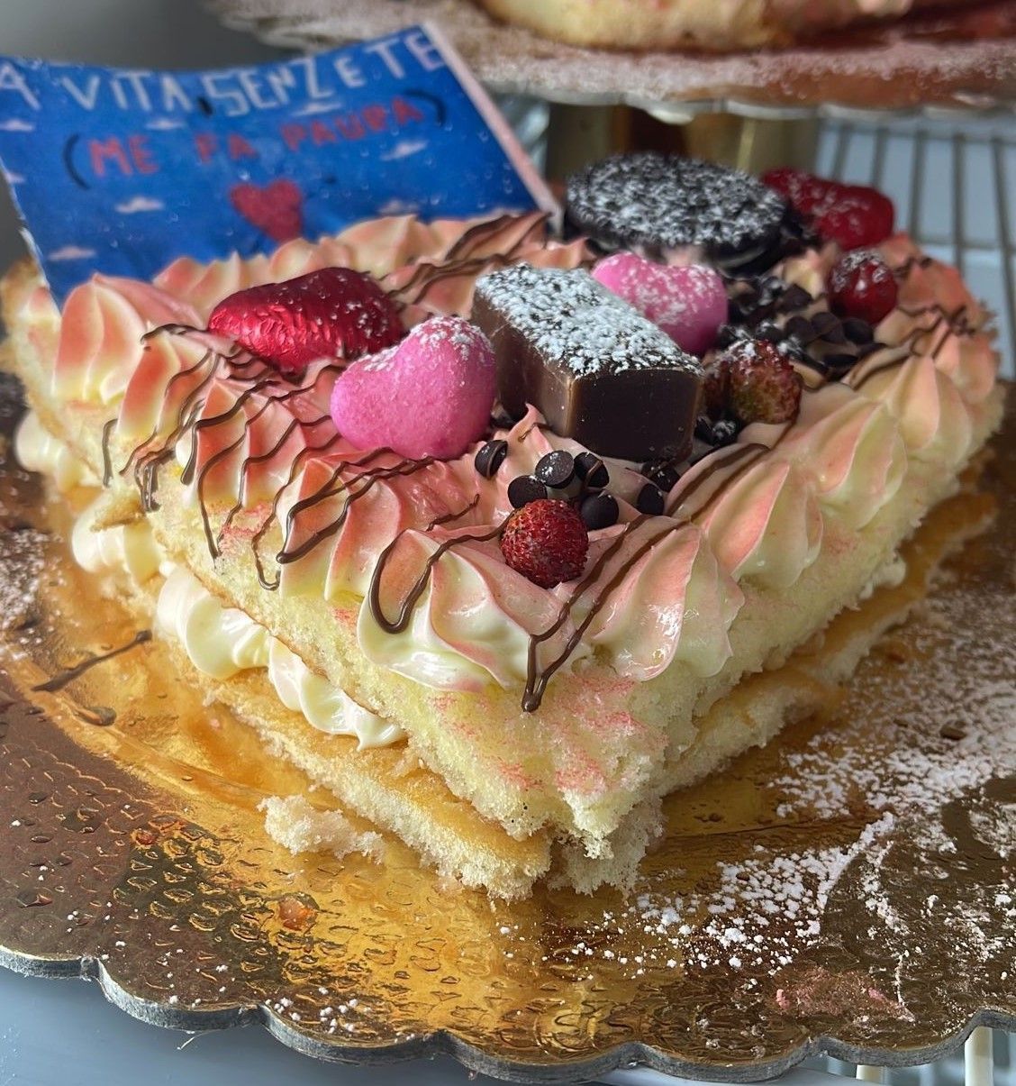 Una torta con glassa rosa e fragole sopra
