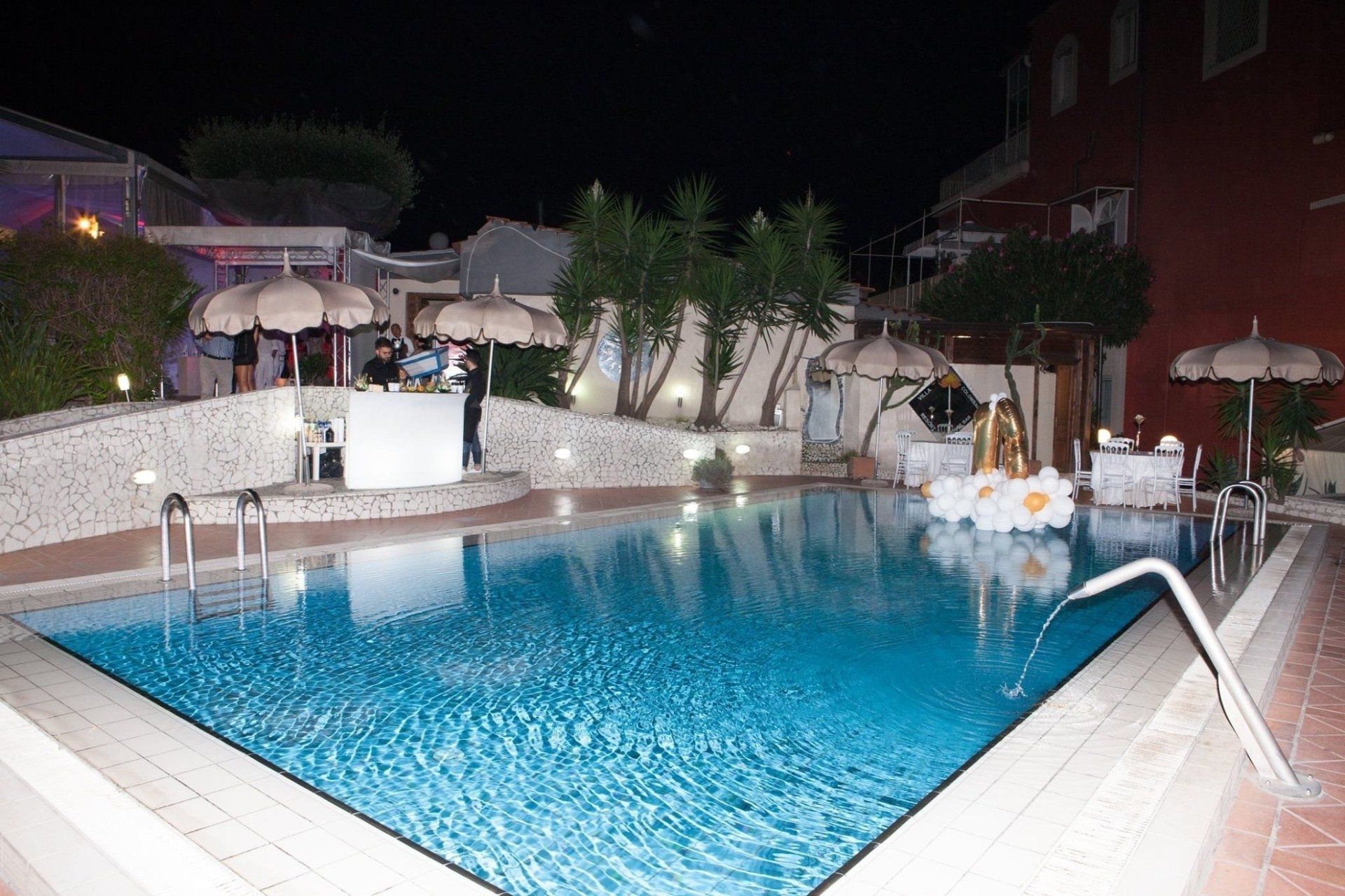 Una grande piscina è illuminata di notte