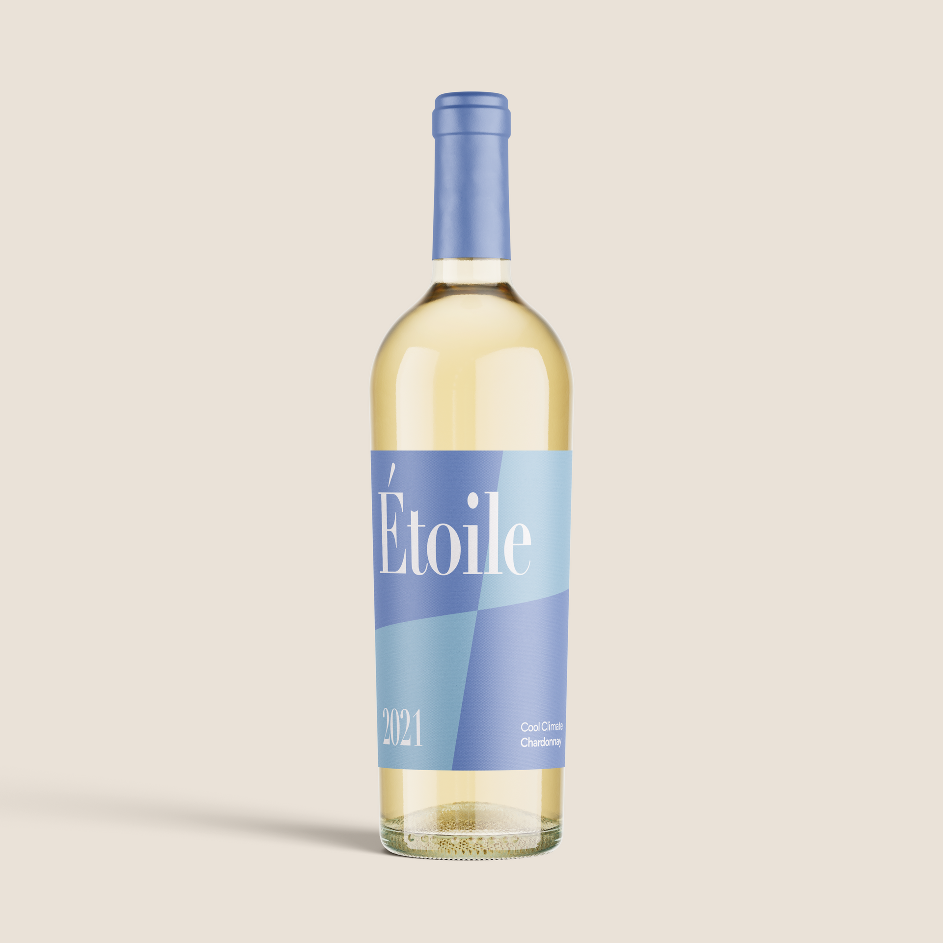 Garrafa de vinho azul e dourada com o rótulo “Etoile” sobre fundo bege, inclinada diagonalmente.