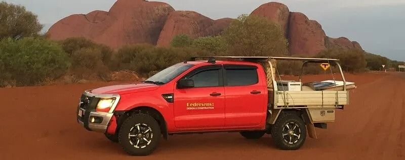 A Red Truck is Parked on a Dirt Road in Front of a Mountain  — Pedersen NT Pty Ltd in Ciccone, NT