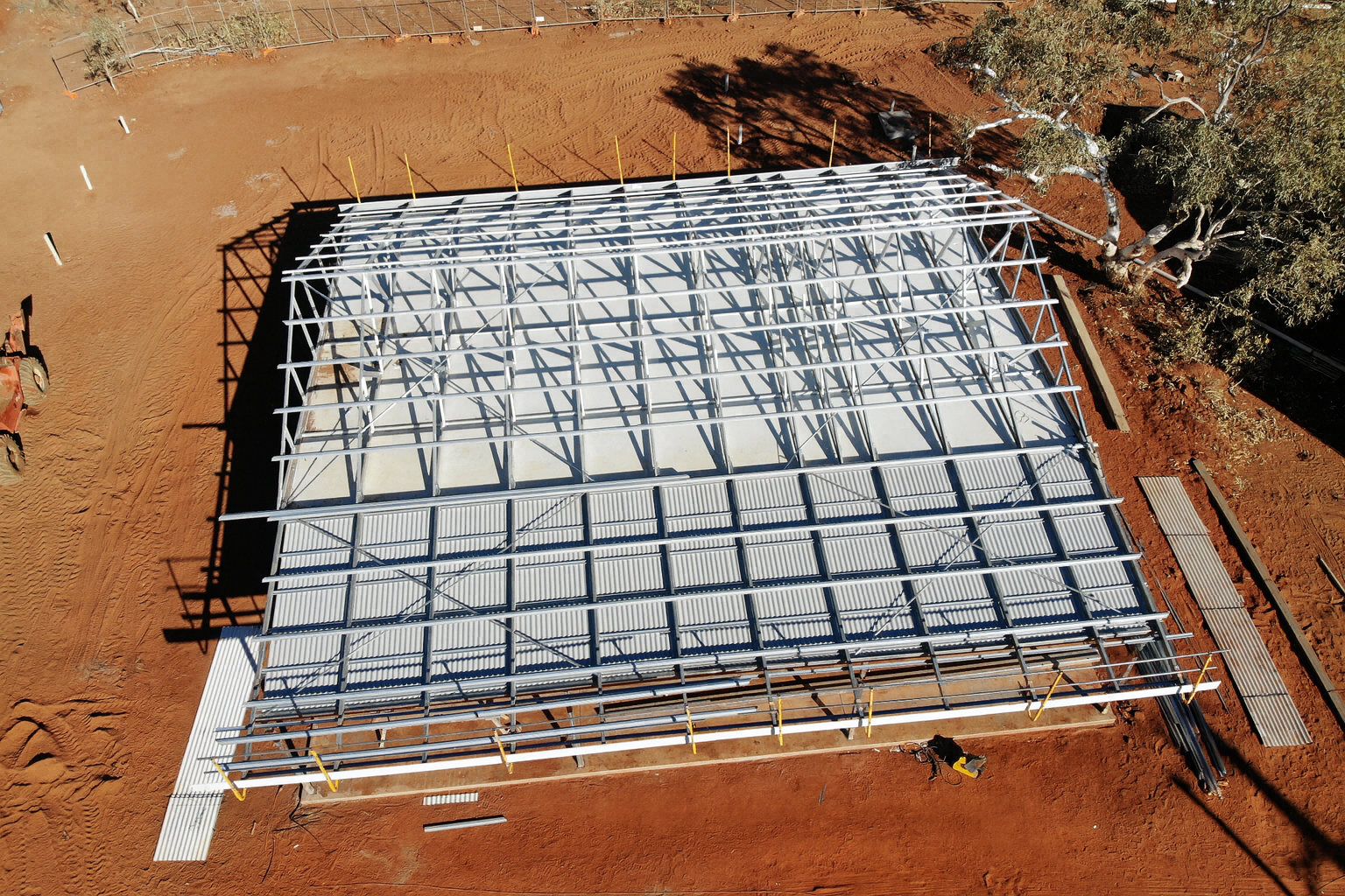 Overhead view of a metal frame roof construction on red dirt — Pedersen NT Pty Ltd in Ciccone, NT