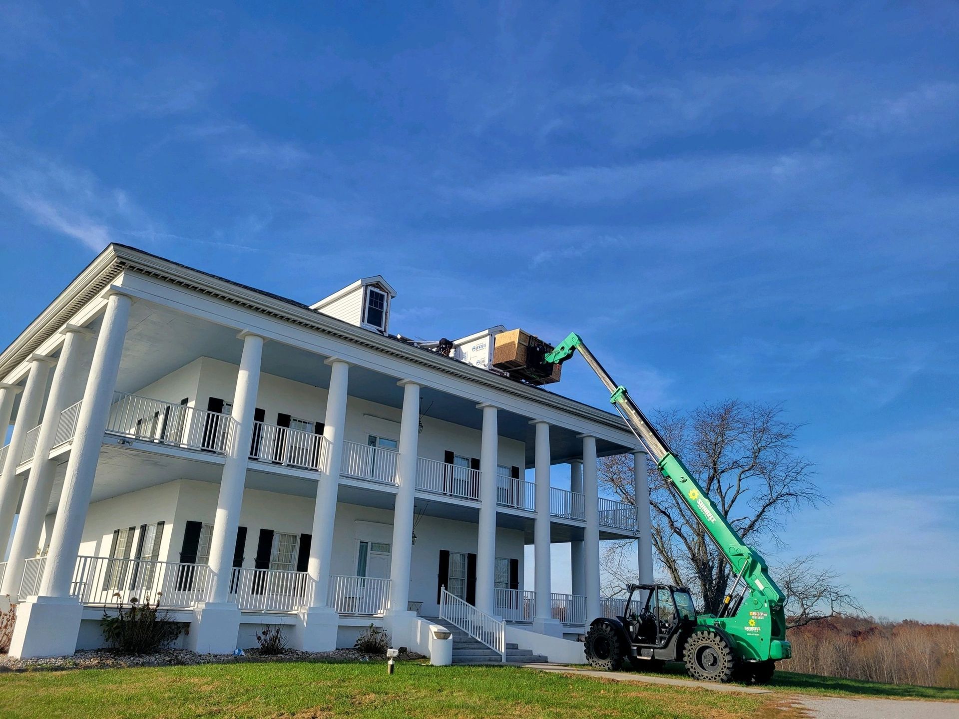 A plumber is fixing a sink in a kitchen with a drill.