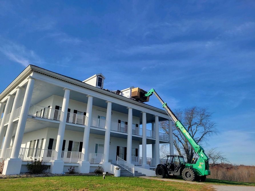 A plumber is fixing a sink in a kitchen with a drill.