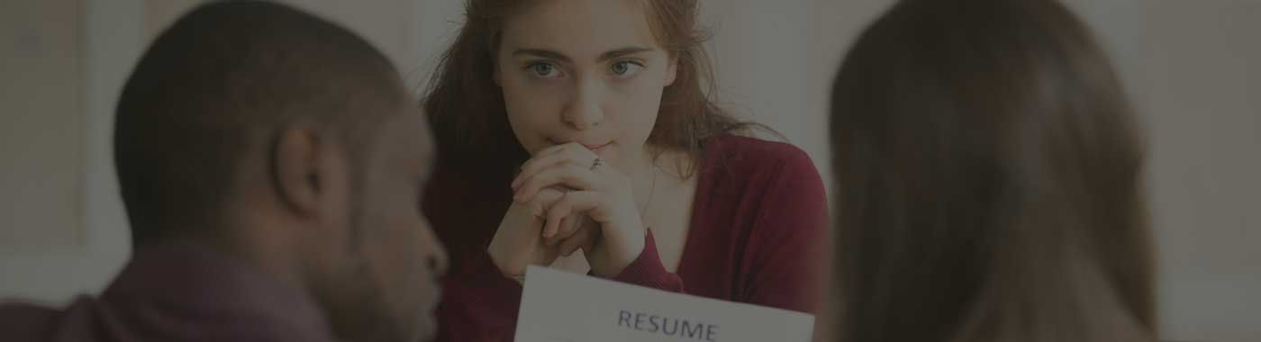 A man is talking to a woman while holding a piece of paper.