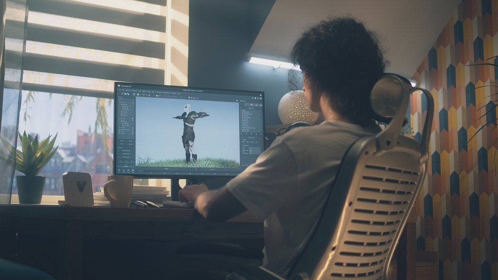 A man is sitting at a desk in front of a computer.