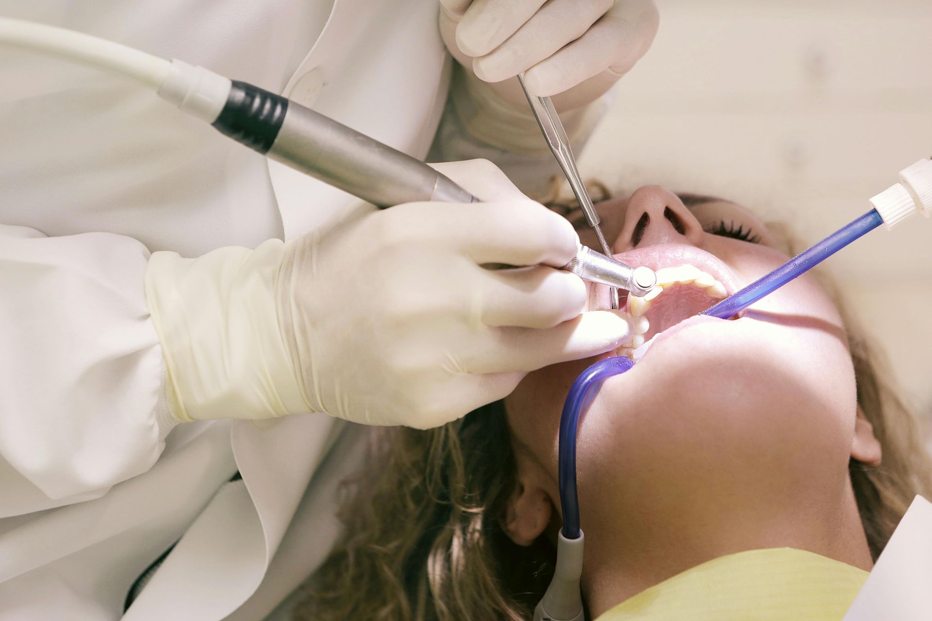 A woman is getting her teeth examined by a dentist