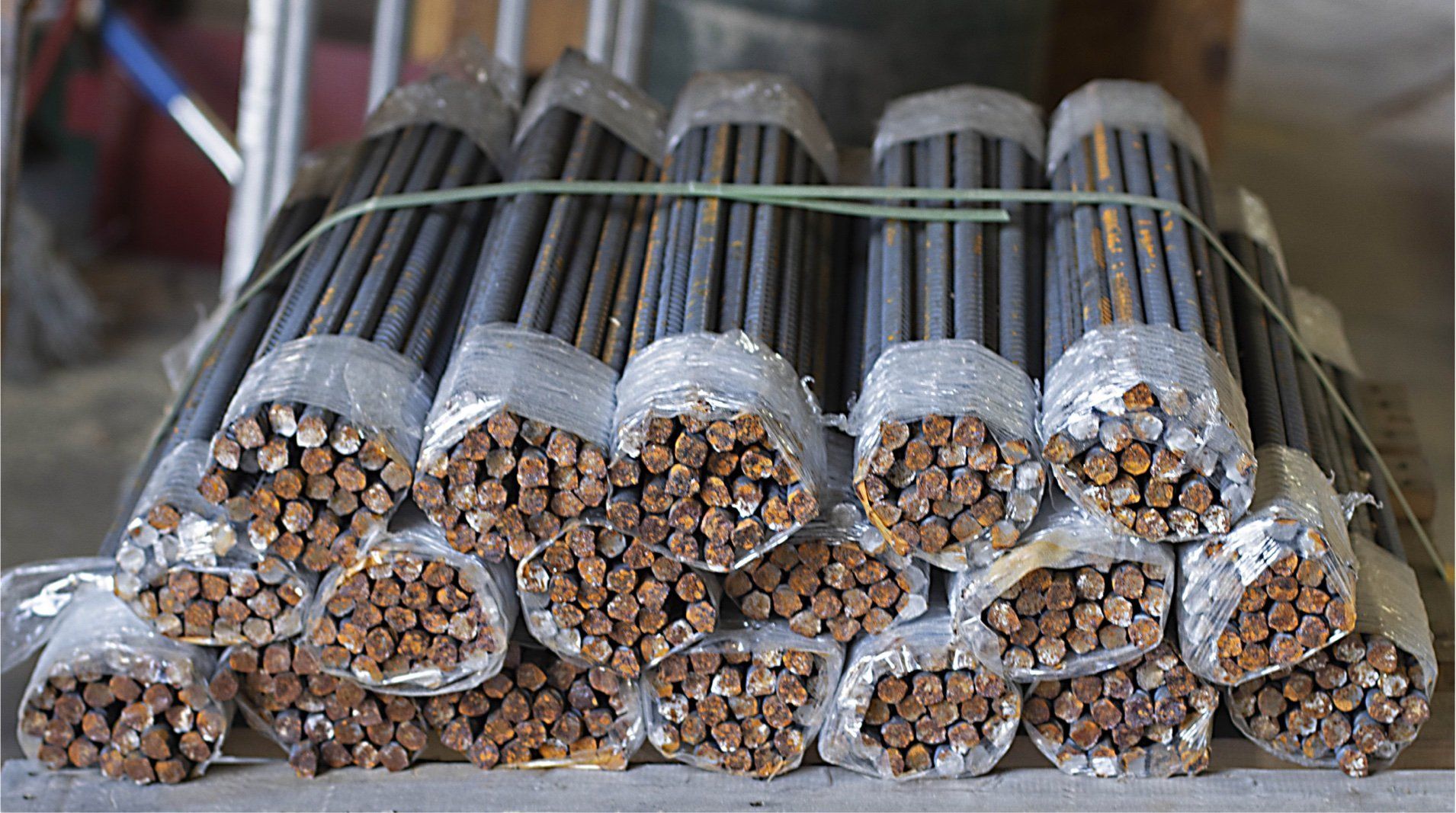 A bunch of rebar wrapped in plastic are stacked on top of each other