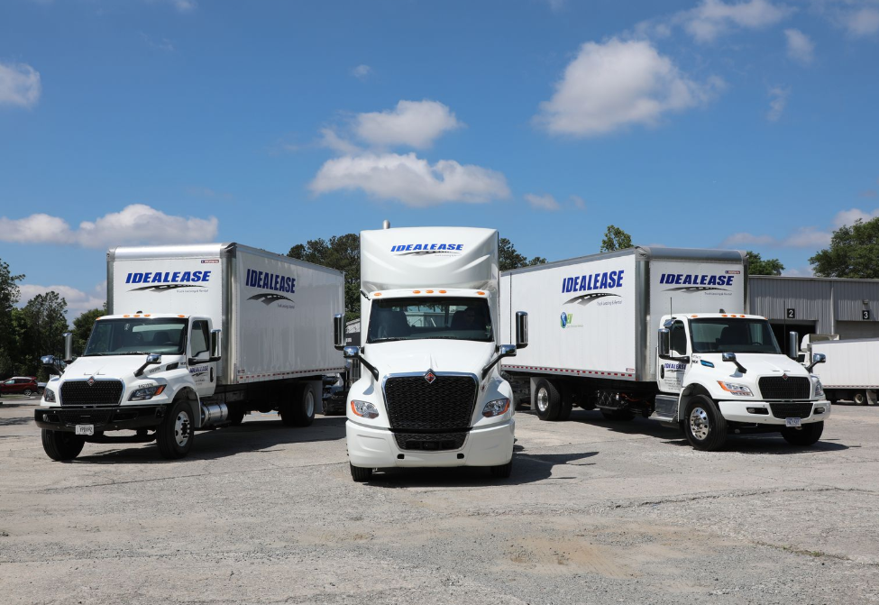 Three trucks are parked next to each other in front of a building.