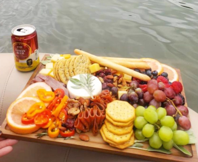 A person is holding a tray of food next to a can of beer