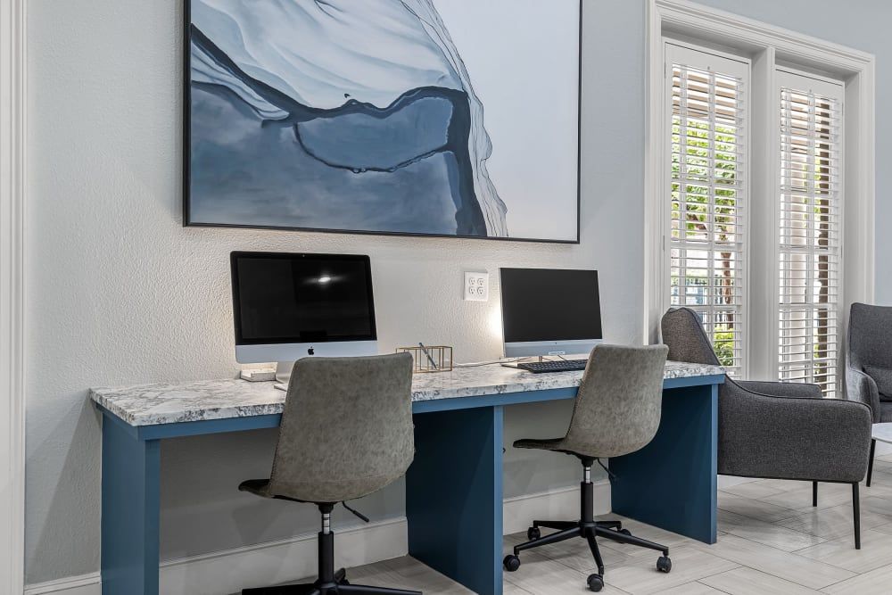 Business center with computer desks, computers, and chairs at Marquis at Silver Oaks in Grapevine, TX.