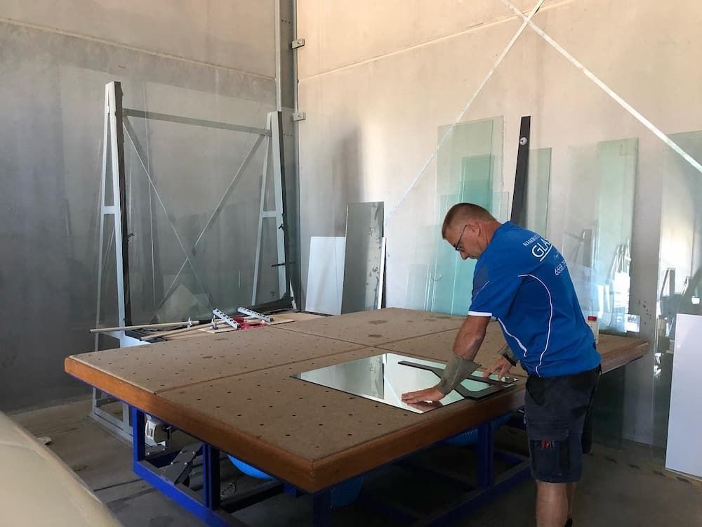 A Man is Focused on a Task at a Glass Table