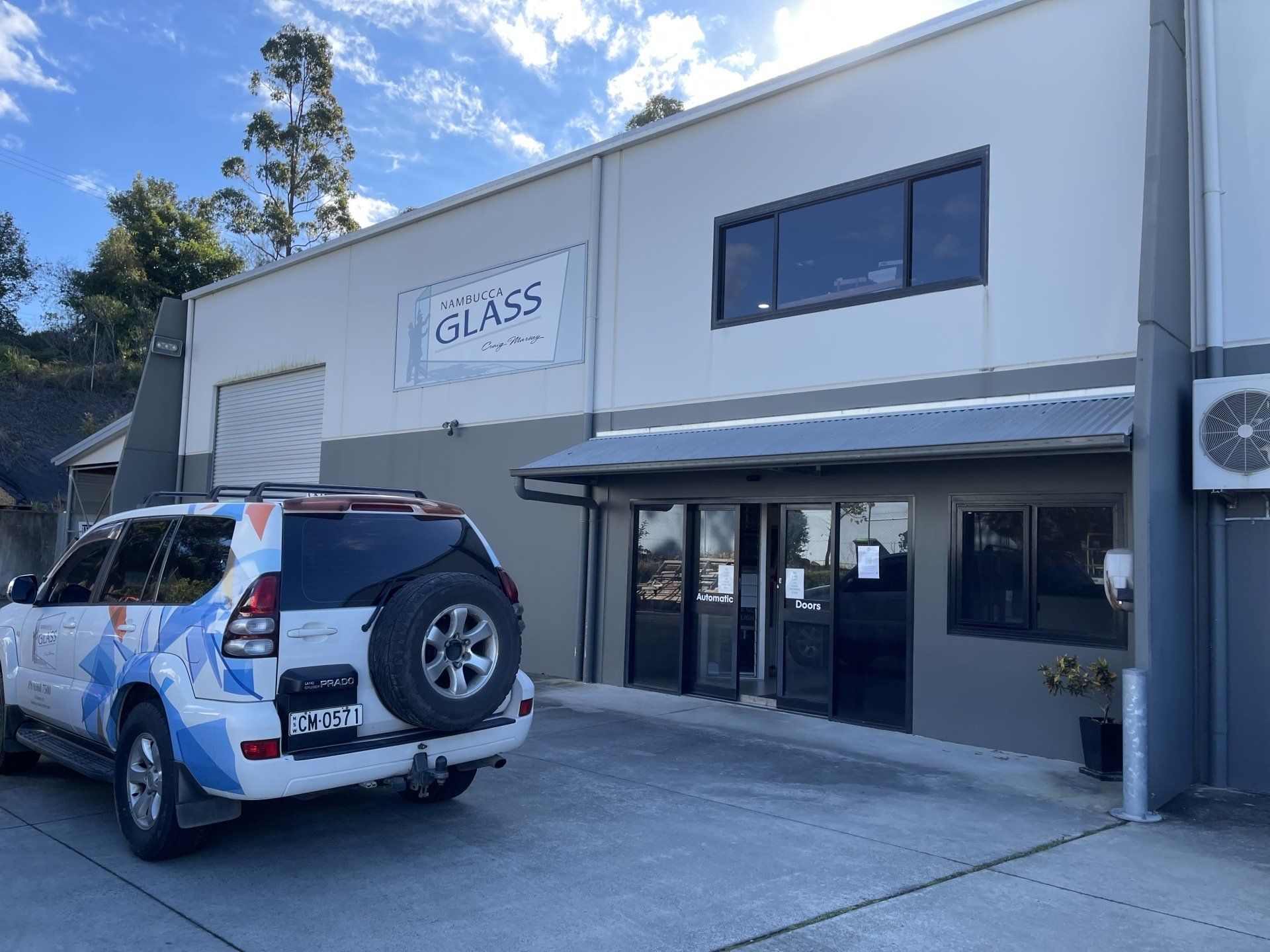 A White Suv Is Parked In Front Of Nambucca Glass Building — Nambucca Glass in Nambucca Heads, NSW
