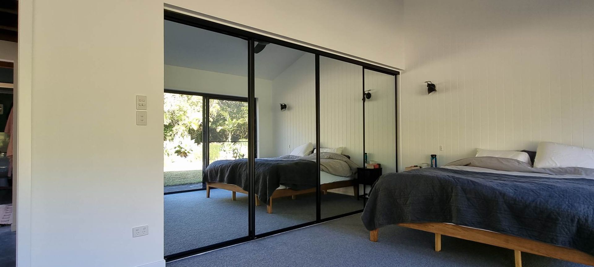 A Bedroom With Two Beds And A Large Mirrored Wall — Nambucca Glass in Nambucca Heads, NSW
