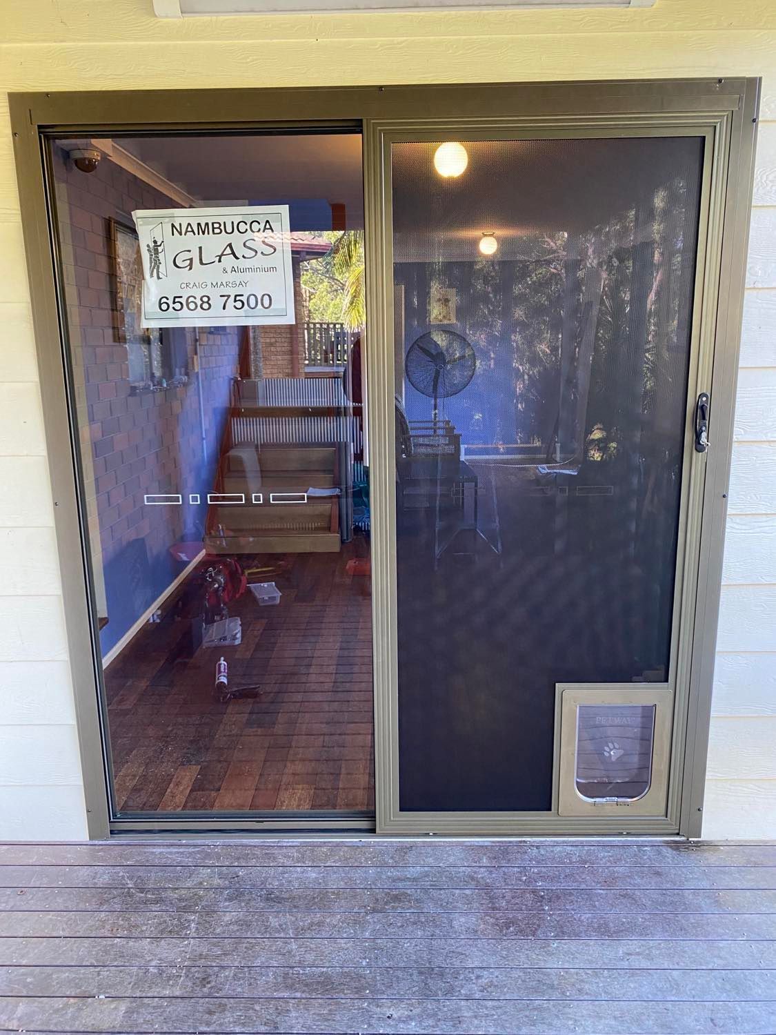 A Sliding Glass Door With A Cat Door In It — Nambucca Glass in Nambucca Heads, NSW
