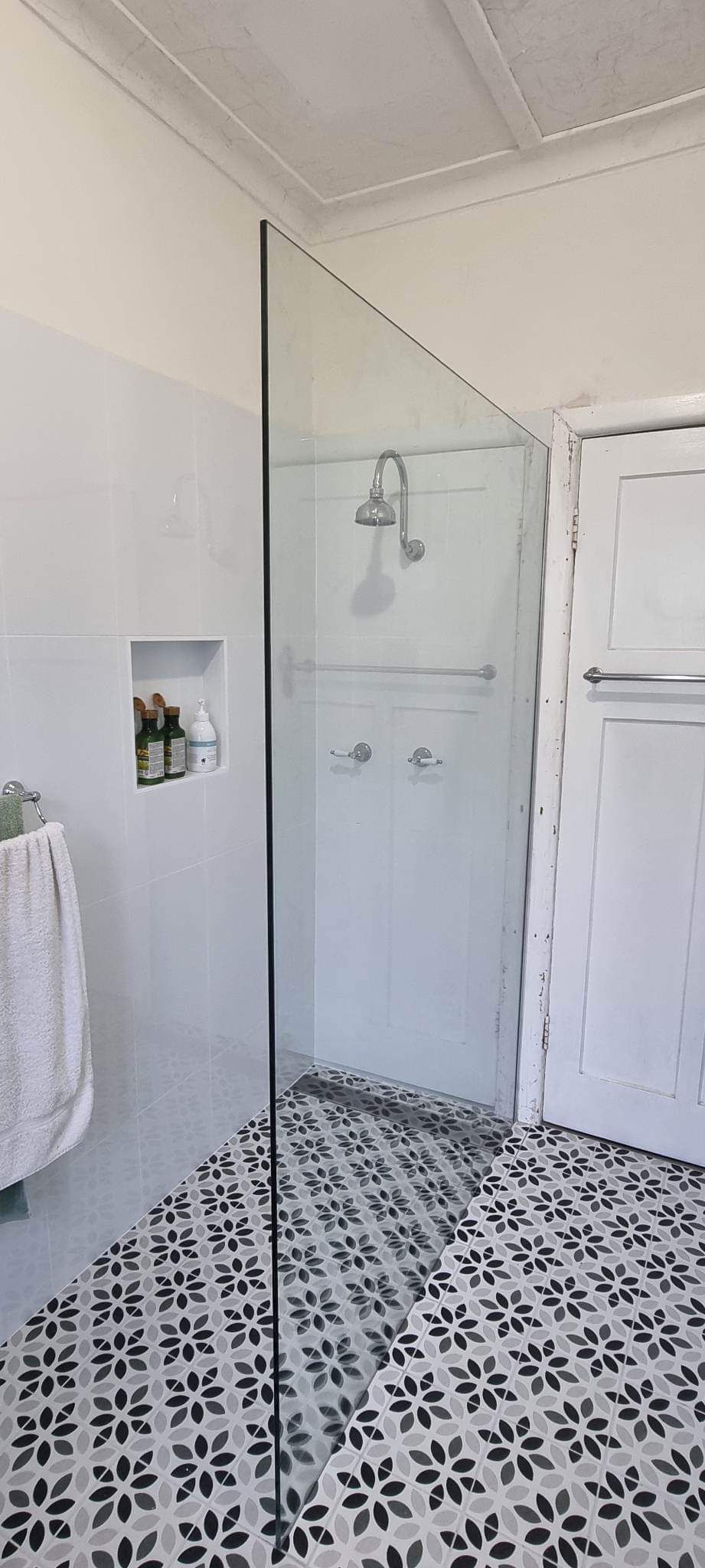 A Bathroom With A Walk In Shower And A Black And White Tile Floor — Nambucca Glass in Nambucca Heads, NSW
