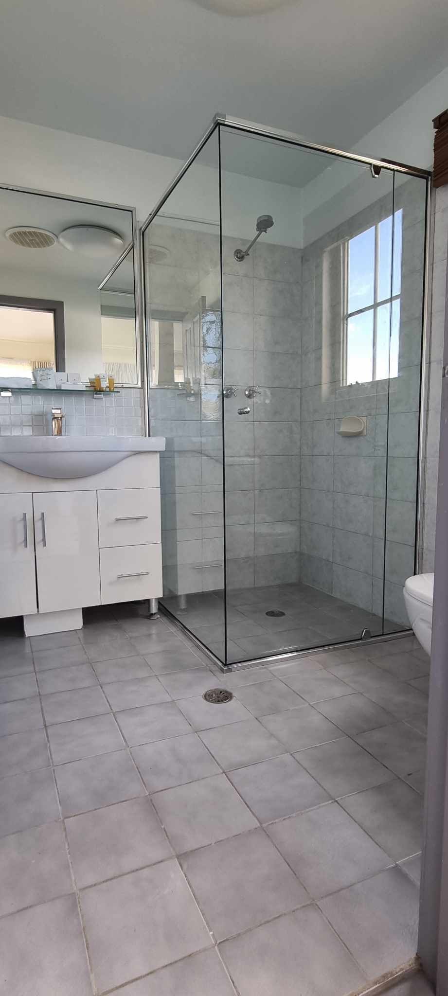 A Bathroom With A Walk In Shower, Sink, Mirror And Toilet — Nambucca Glass in Nambucca Heads, NSW