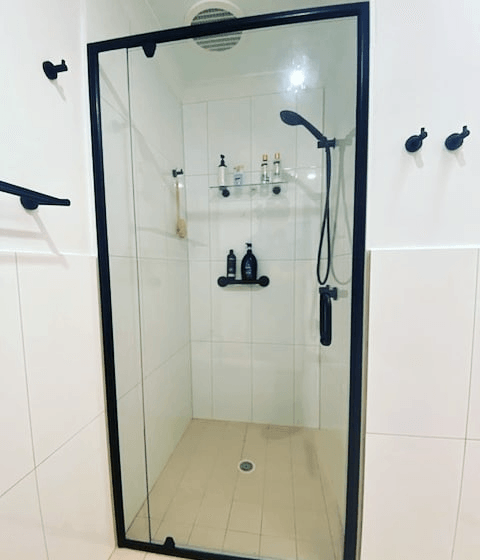 A Shower With A Glass Door And A Black Frame — Nambucca Glass in Nambucca Heads, NSW