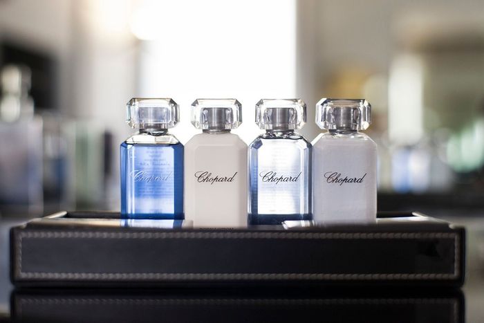 Four bottles of chopard perfume are on a tray