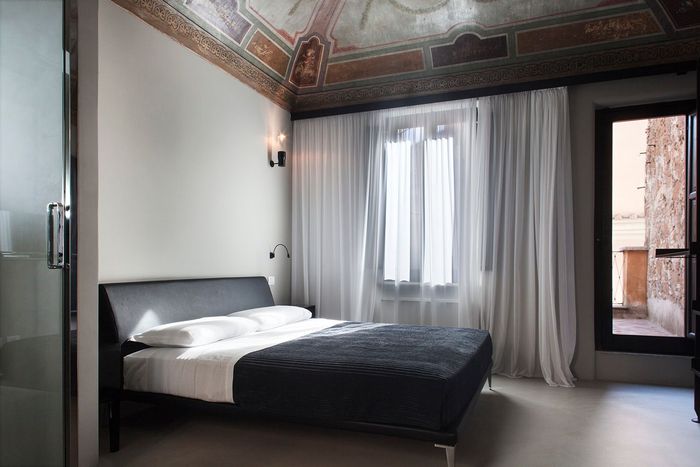 A bedroom with a large bed and a window