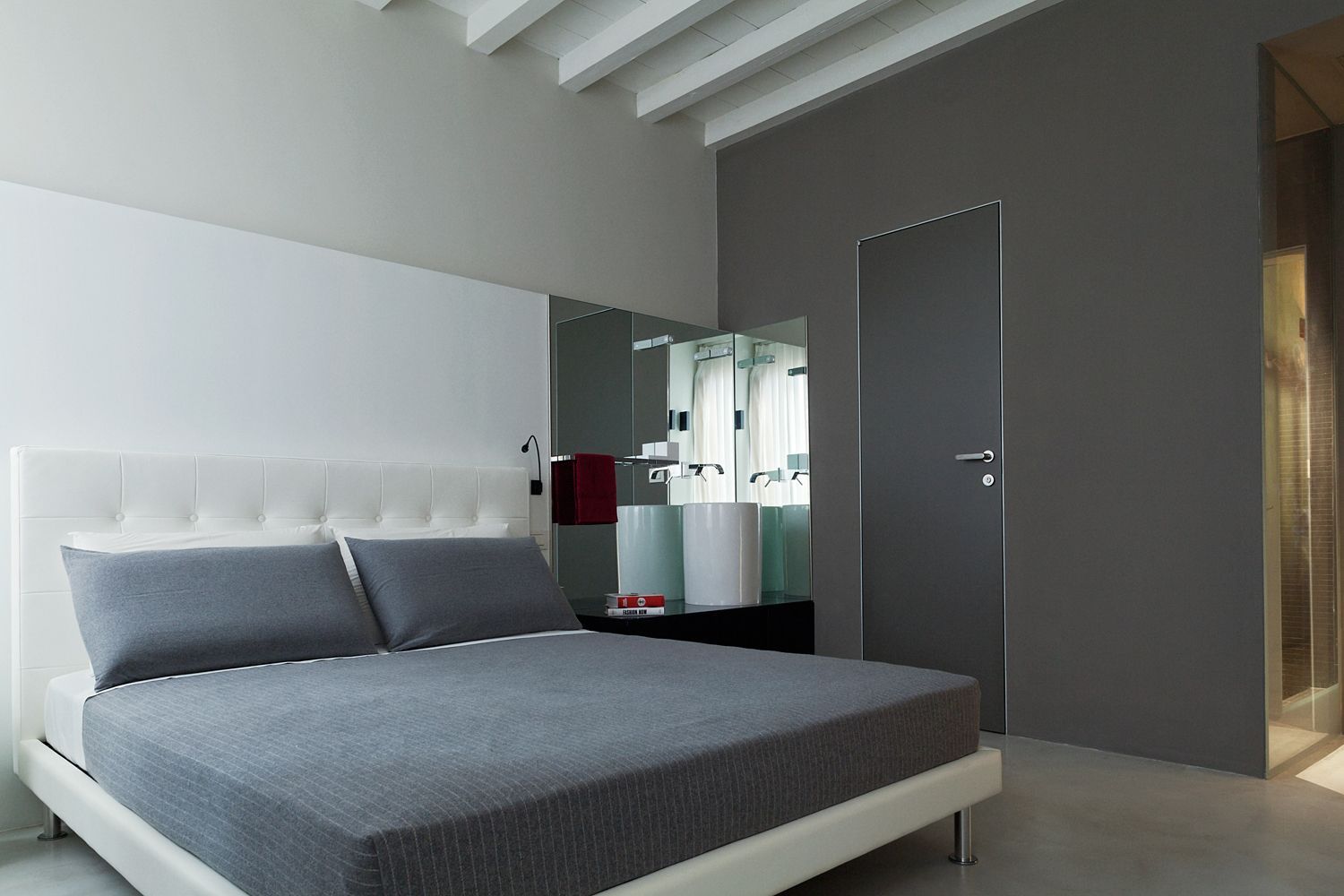 Un dormitorio con una cama y un baño al fondo.
