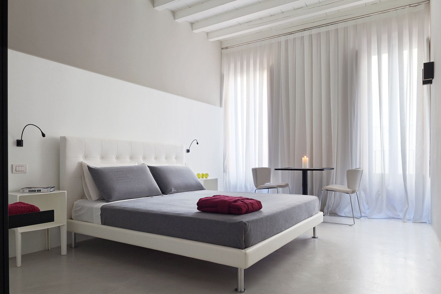 Un dormitorio con una cama grande y una mesa pequeña.