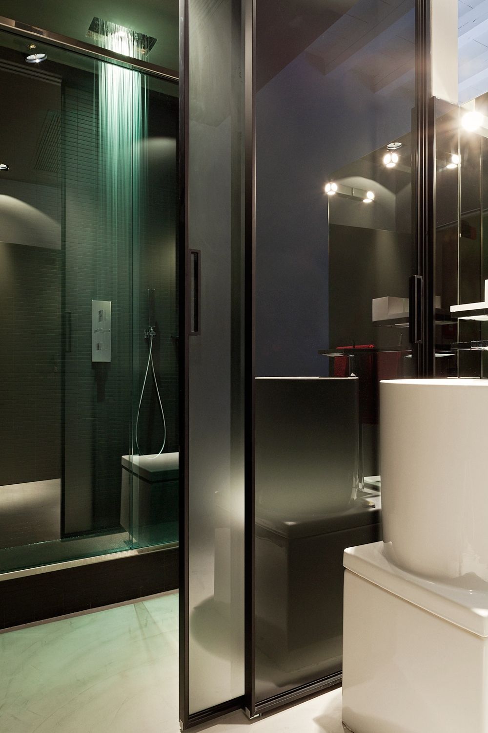 Un baño con puerta corrediza de cristal y lavabo.