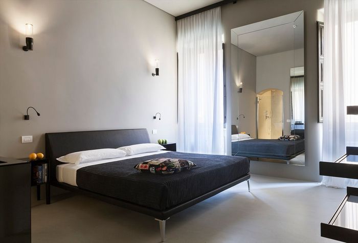 A bedroom with a large mirror and a large bed