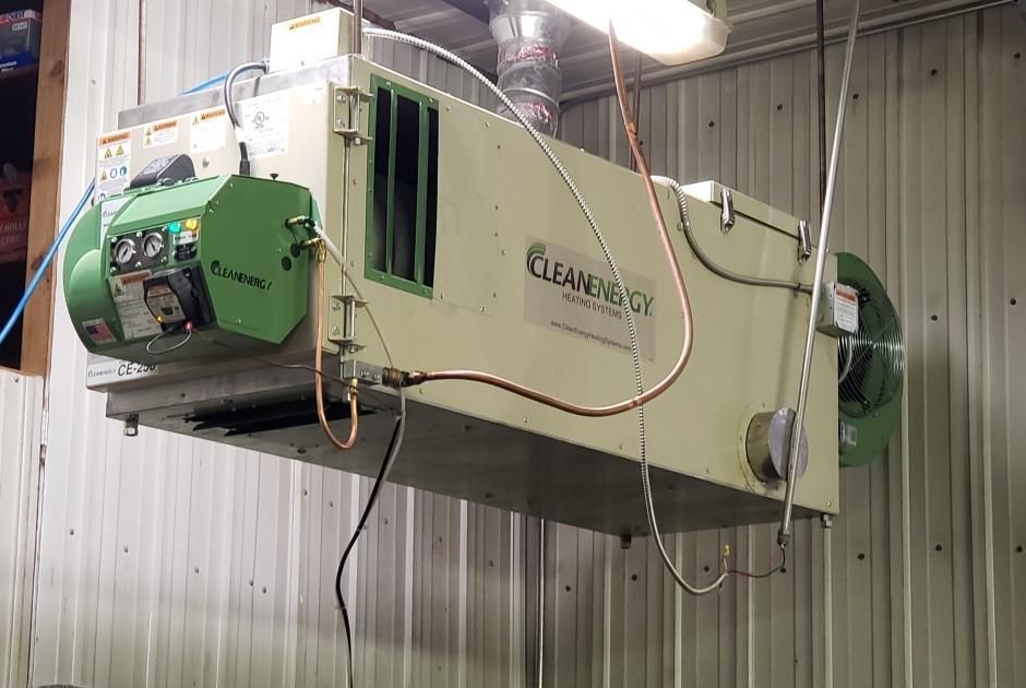 A green and white machine is hanging from the ceiling of a building.