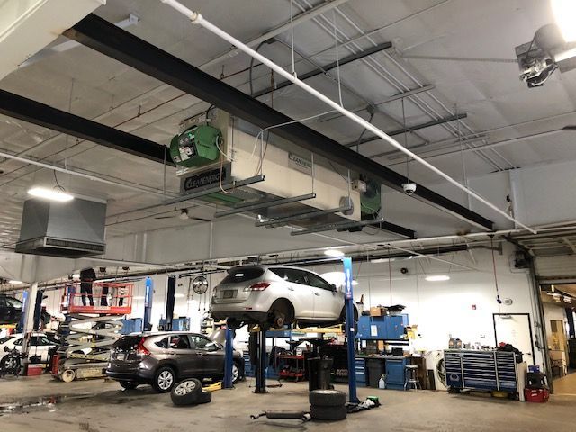 A car is sitting on a lift in a garage.