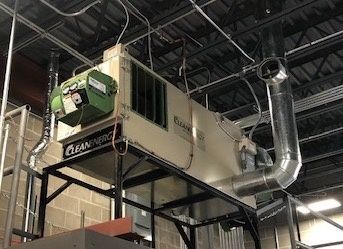 A large machine is hanging from the ceiling of a building.